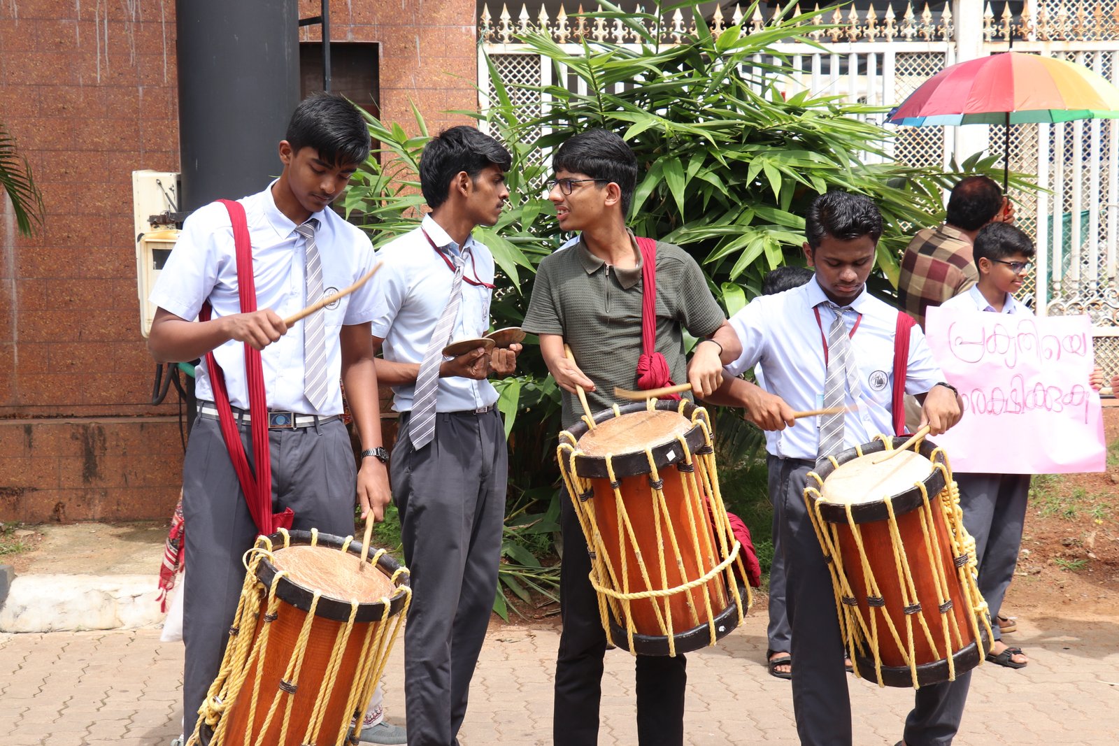 Students perform with drums during a public awareness campaign