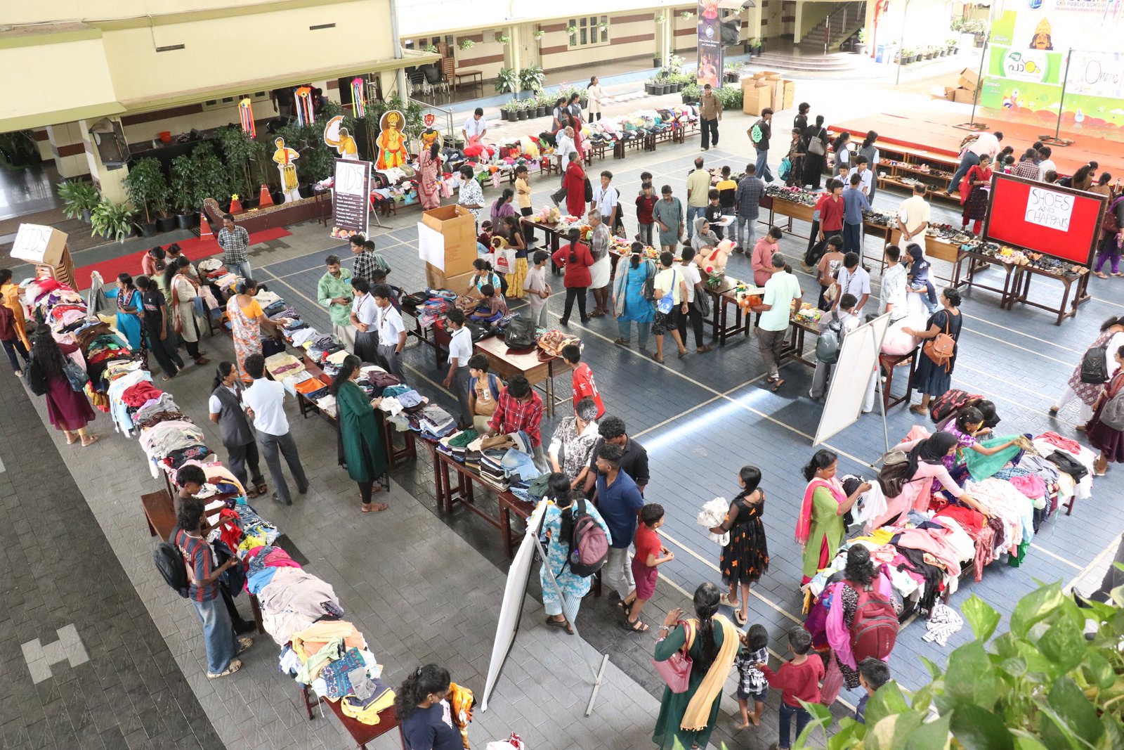 A busy school flea market with donated clothes and household items